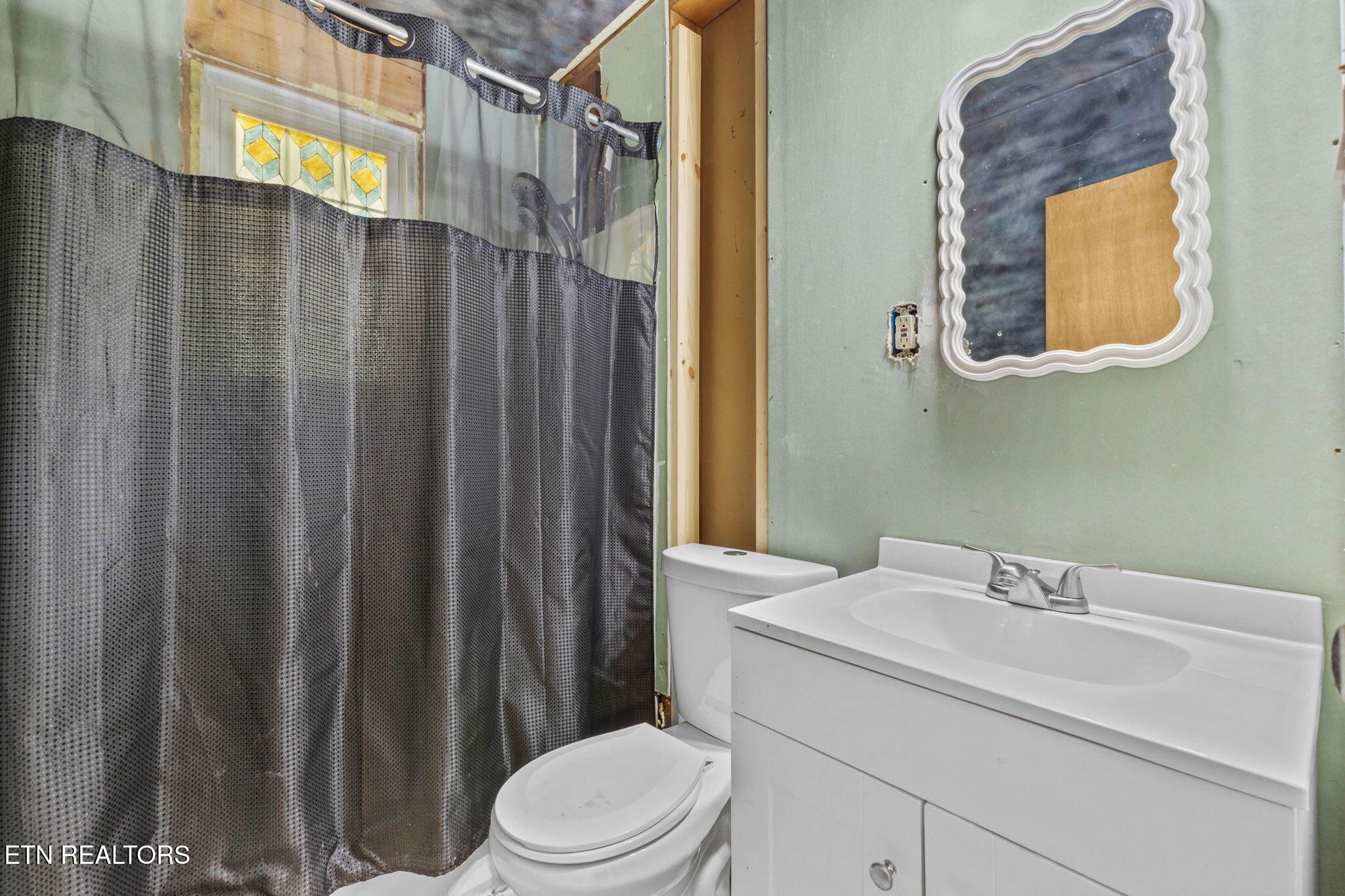 302 Hickory Street Clinton, TN 37716 - Photo 29 of 38 a bathroom with a sink a toilet and shower curtain