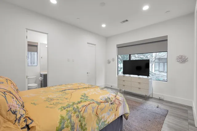 a bedroom with a bed and a flat screen tv