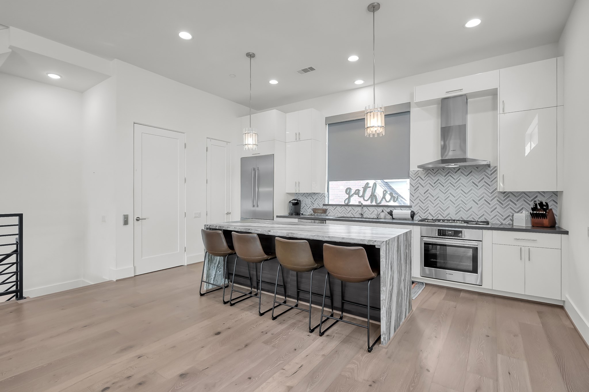 3207 Revere Street Houston, TX 77098 - Photo 18 of 50 a kitchen with granite countertop wooden floor white cabinets and stainless steel appliances