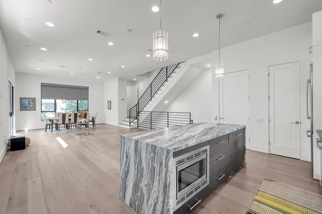 a kitchen with stainless steel appliances kitchen island a stove and a wooden floors