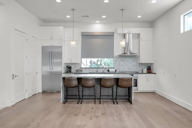 a kitchen with granite countertop a table chairs sink and cabinets