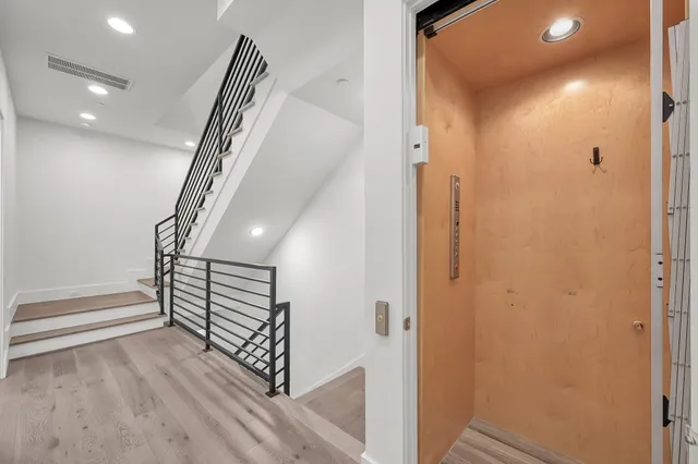 a view of a hallway with wooden floor and stairs
