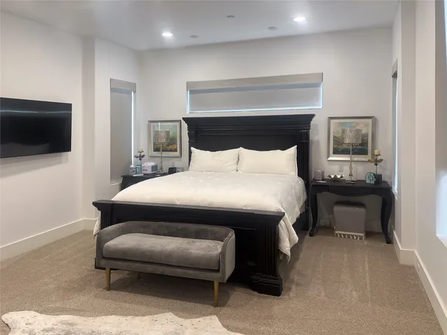 a bedroom with a bed a television and a couch