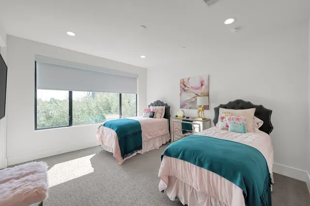 a bedroom with two beds and a large window