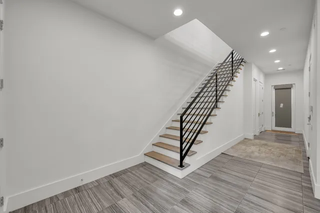 a view of a hallway with wooden floor and staircase