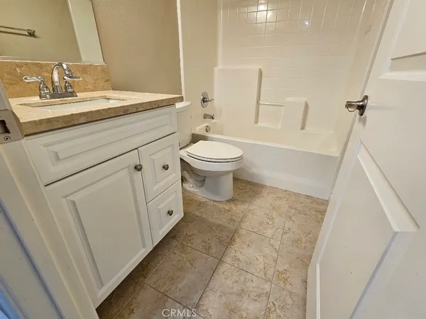 a spacious bathroom with a granite countertop sink a toilet and a mirror