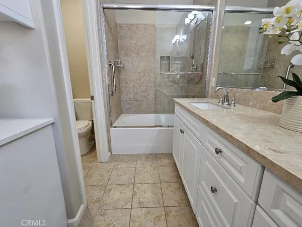a bathroom with a granite countertop sink a mirror and a bathtub