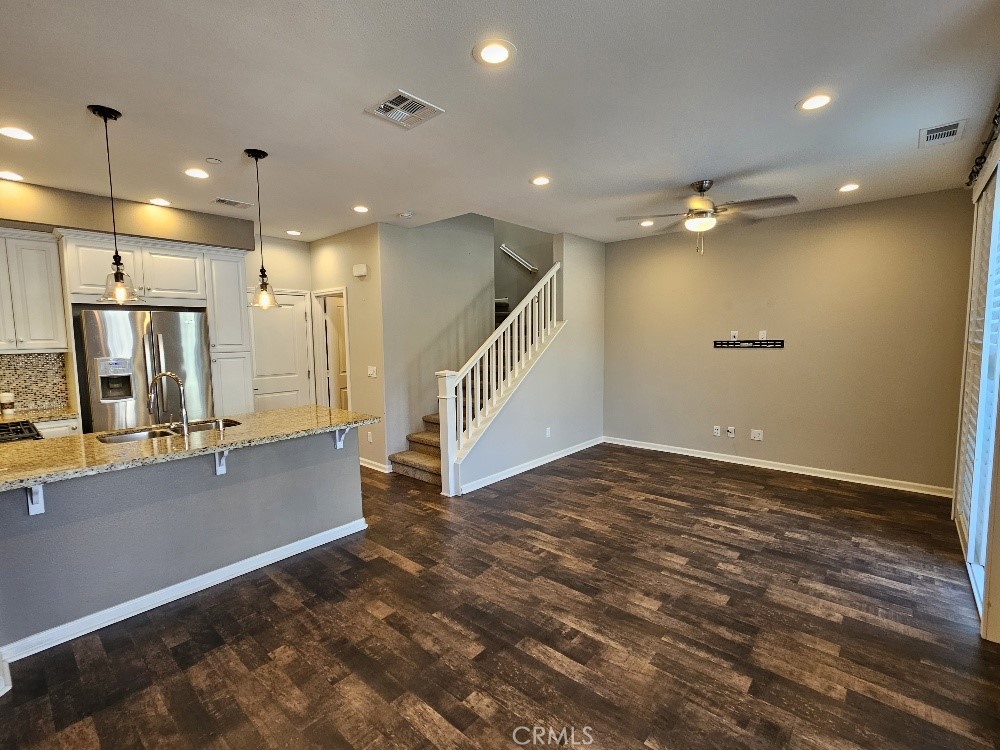 44011 Rivo Court Temecula, CA 92592 - Photo 5 of 34 a view of an empty room with wooden floor and a bathroom