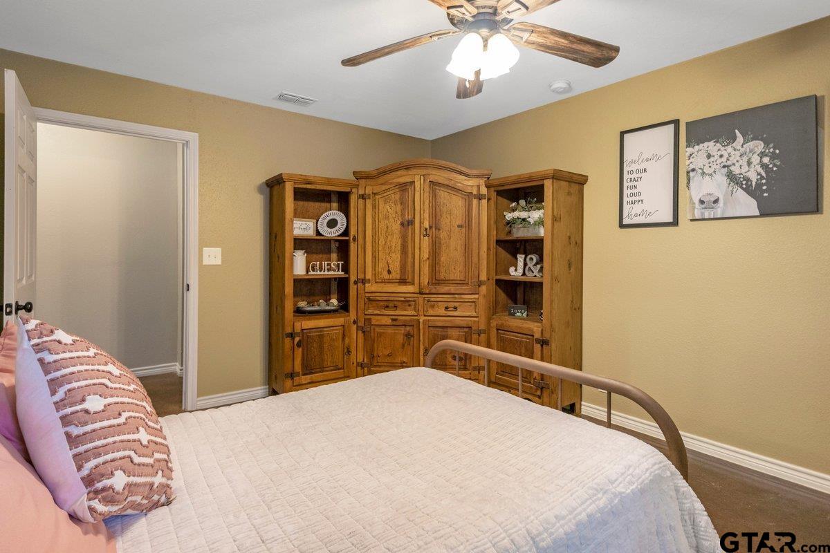 1254 Corinth Road Jacksonville, TX 75766 - Photo 16 of 42 a bedroom with a bed and a chandelier