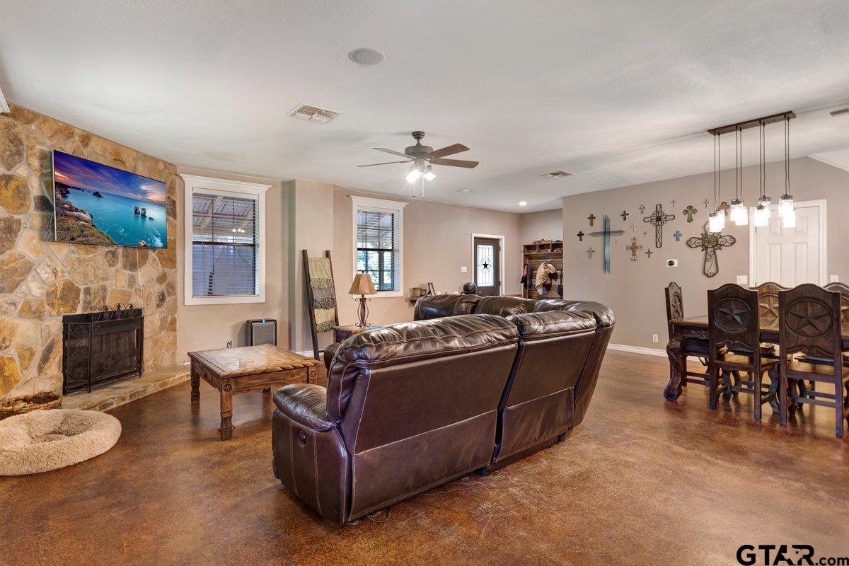 1254 Corinth Road Jacksonville, TX 75766 - Photo 29 of 42 a living room with furniture a fireplace and a dining table with a fireplace