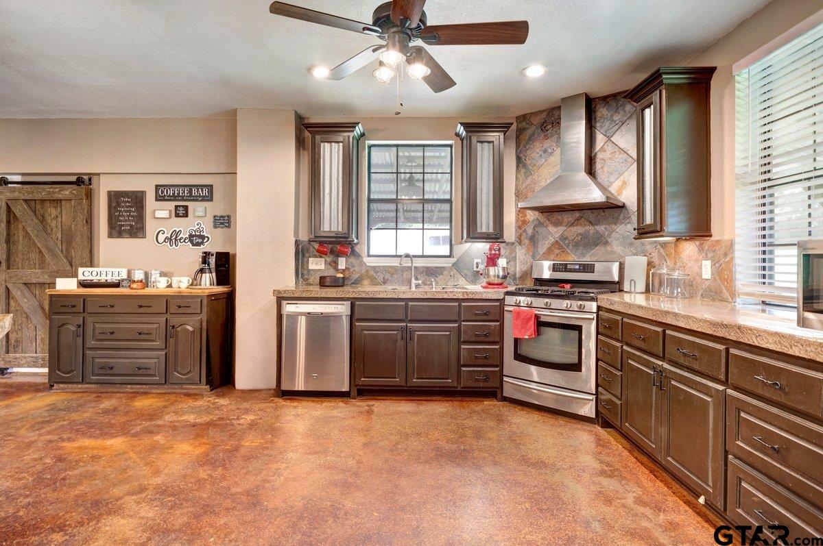 1254 Corinth Road Jacksonville, TX 75766 - Photo 35 of 42 a kitchen with stainless steel appliances kitchen island granite countertop a stove a sink and a refrigerator