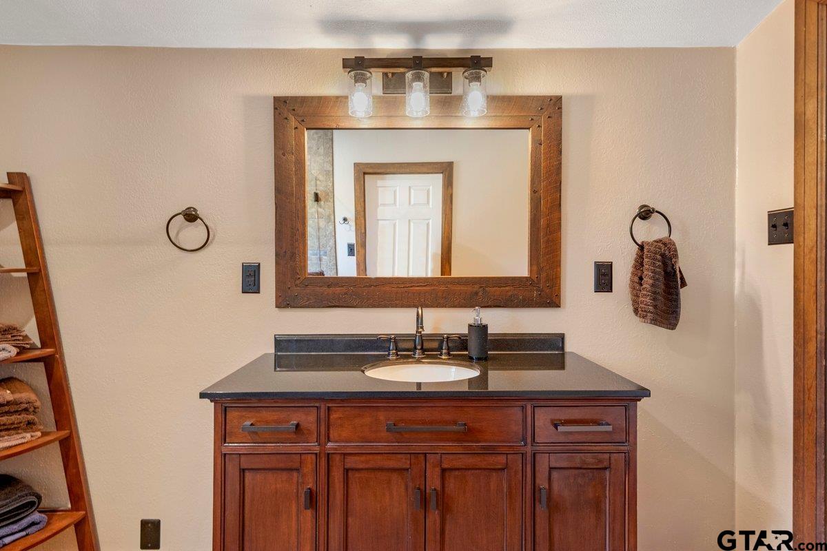 1254 Corinth Road Jacksonville, TX 75766 - Photo 7 of 42 a bathroom with a sink and a mirror