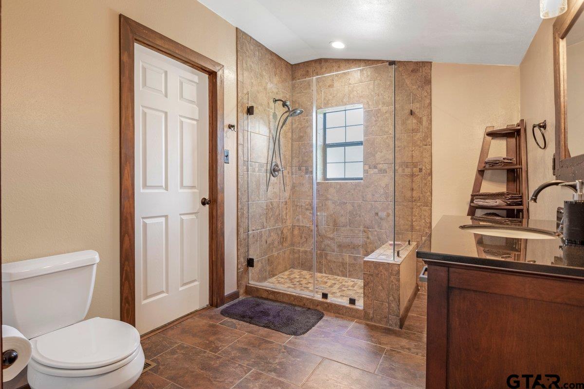 1254 Corinth Road Jacksonville, TX 75766 - Photo 8 of 42 a bathroom with a granite countertop sink a toilet and shower