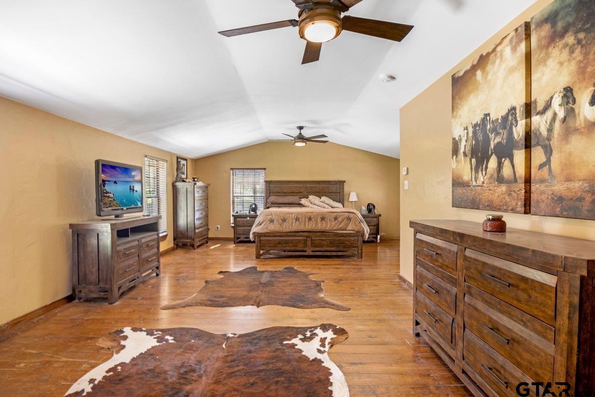 1254 Corinth Road Jacksonville, TX 75766 - Photo 10 of 42 a spacious bedroom with a bed and a chandelier
