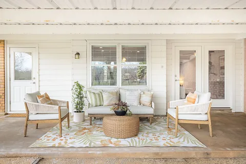 a view of a house with backyard and sitting area