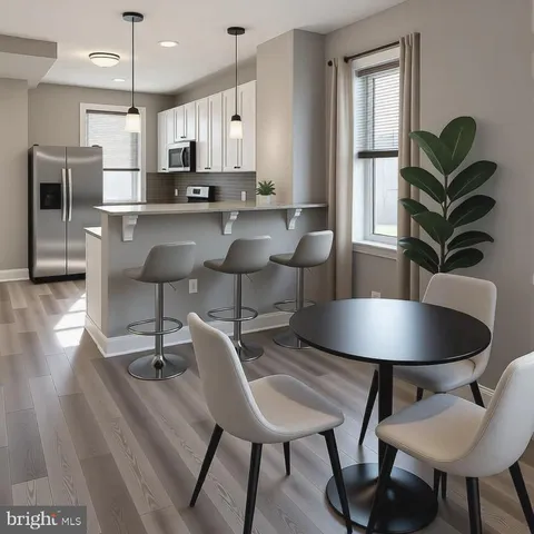 a kitchen with granite countertop kitchen island stainless steel appliances a dining table chairs sink and cabinets