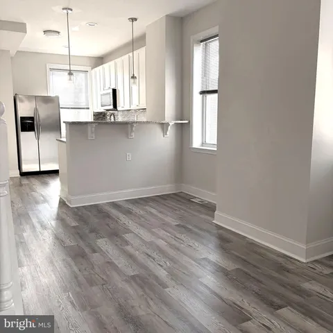 a view of a kitchen with wooden floor and electronic appliances