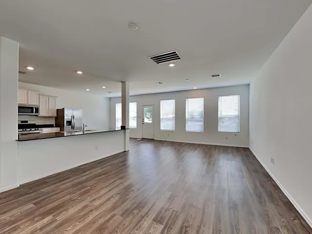 a kitchen with stainless steel appliances kitchen island granite countertop a stove a refrigerator and a sink