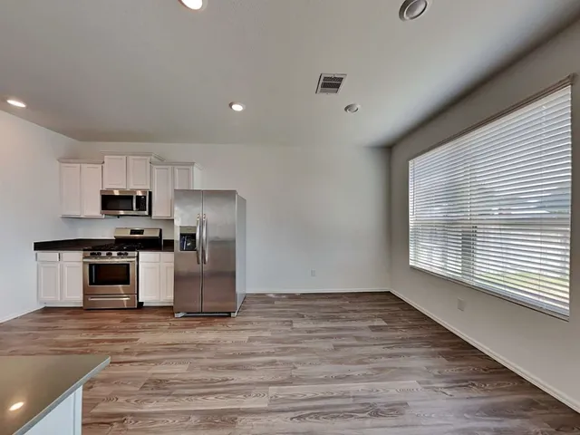 a kitchen with sink wooden floor and stainless steel appliances