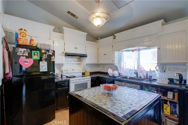 a kitchen with stainless steel appliances granite countertop a stove top oven a sink and cabinets