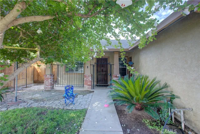 a front view of a house with a tree