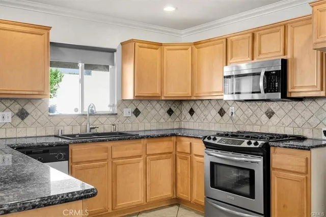 a kitchen with granite countertop a stove sink and cabinets