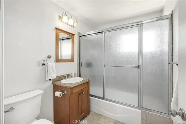 a bathroom with a granite countertop sink mirror vanity and toilet