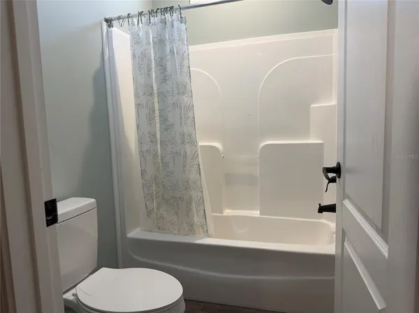 a bathroom with a toilet and a shower