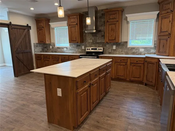 a kitchen with stainless steel appliances granite countertop a refrigerator a sink dishwasher a stove with wooden cabinets and floor
