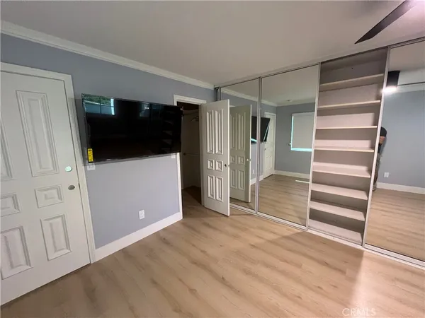a view of an empty room with wooden floor and stairs