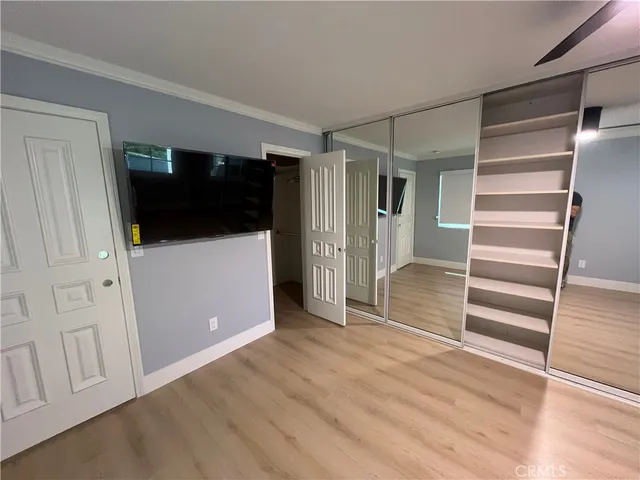 a view of an empty room with wooden floor and stairs