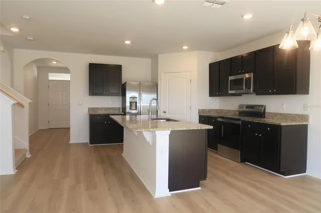 a kitchen with stainless steel appliances granite countertop a sink and a microwave