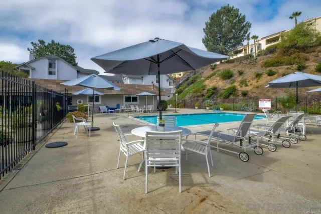 a view of a patio with a table and chairs under an umbrella
