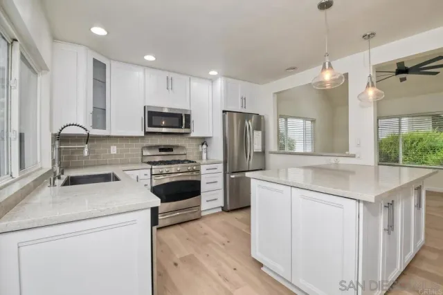 a kitchen with kitchen island granite countertop appliances cabinets and a sink
