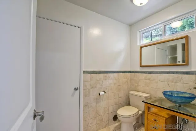 a bathroom with a toilet a sink and mirror