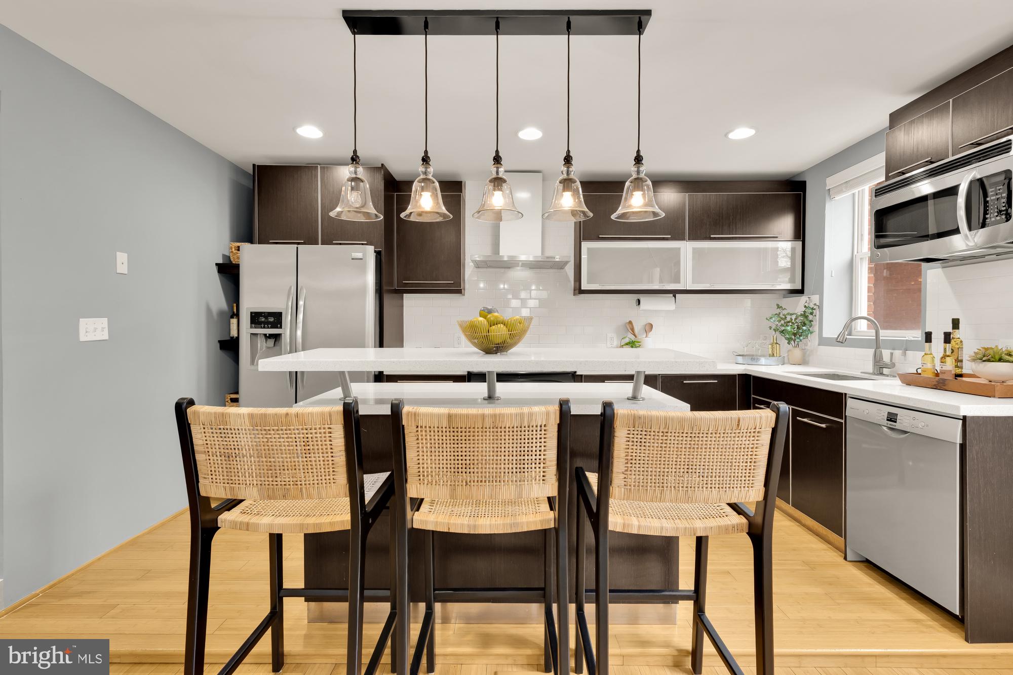1409 G Street Northeast, Unit 5 Washington, DC 20002 - Photo 5 of 29 a kitchen with stainless steel appliances kitchen island granite countertop a table and chairs