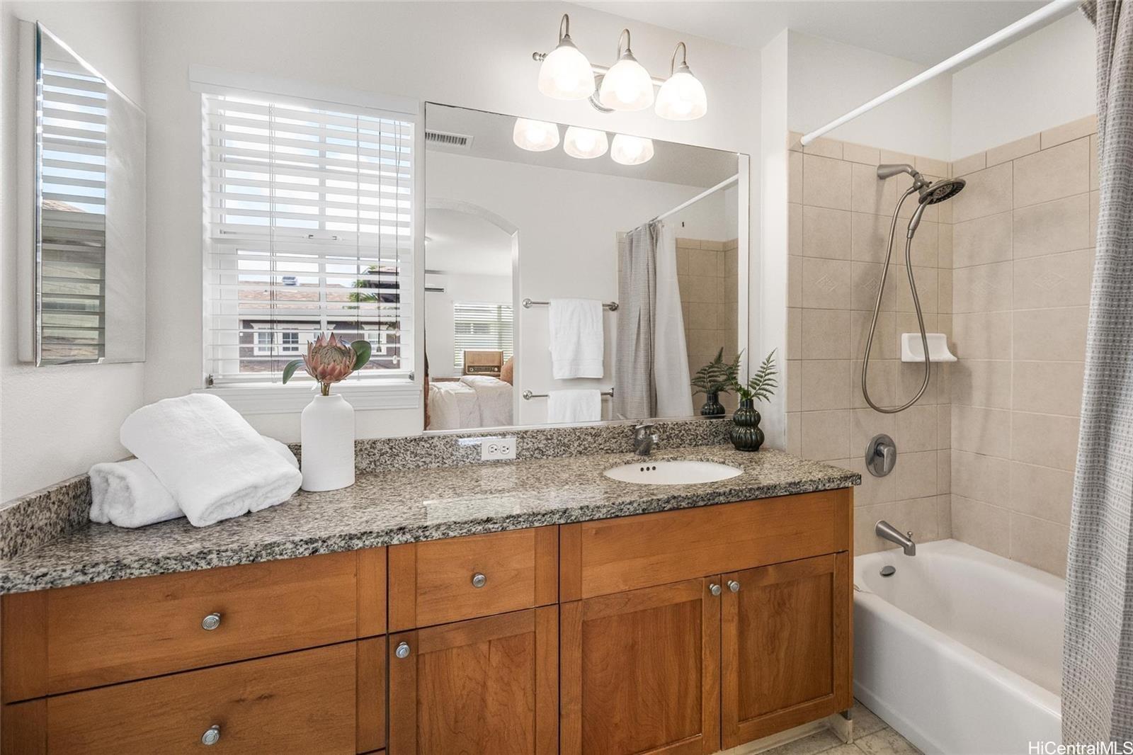 520 Lunalilo Home Road, Unit 313 Honolulu, HI 96825 - Photo 16 of 25 a bathroom with a granite countertop sink a toilet and bathtub