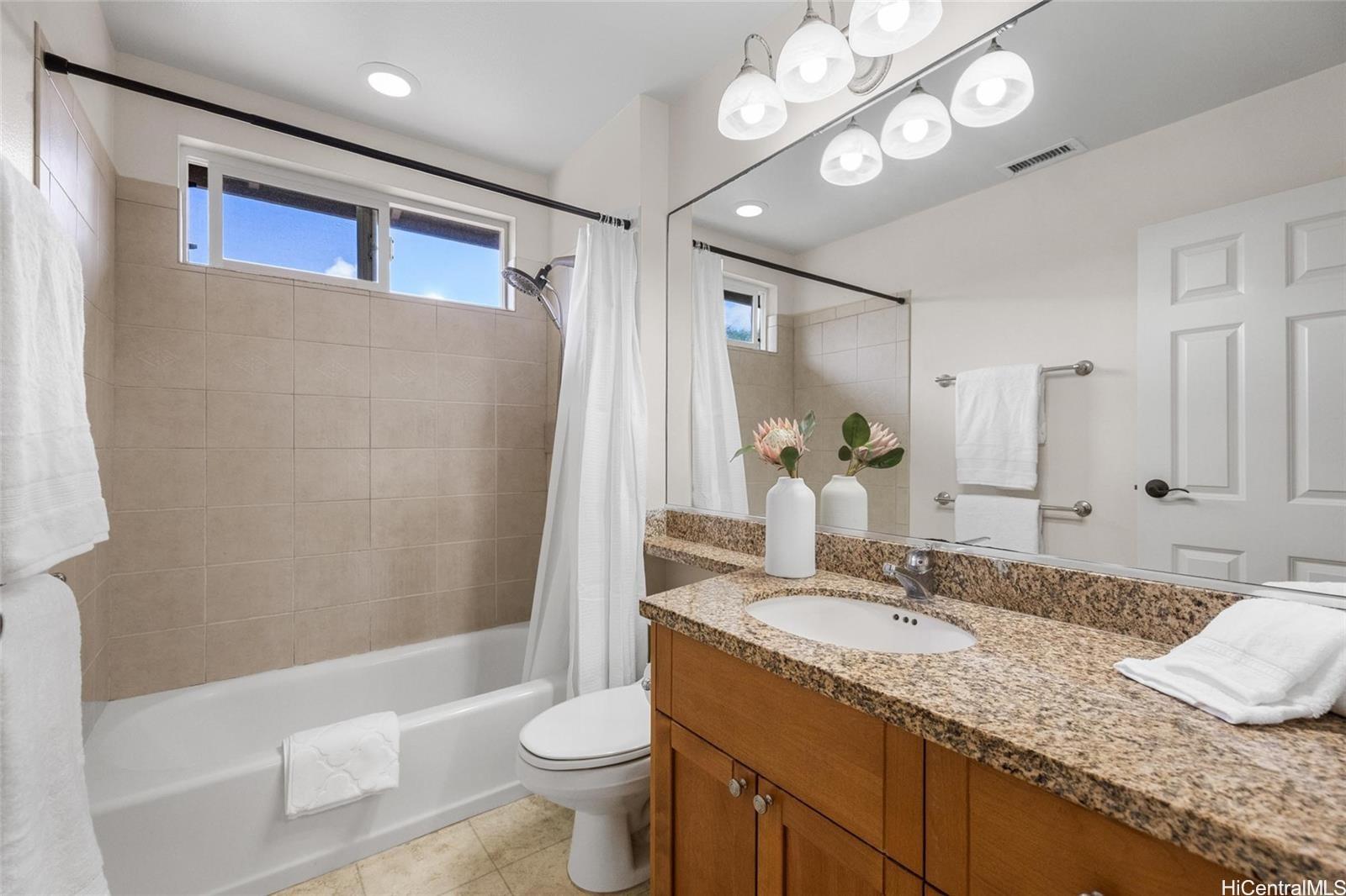520 Lunalilo Home Road, Unit 313 Honolulu, HI 96825 - Photo 18 of 25 a bathroom with a granite countertop sink a toilet and bathtub