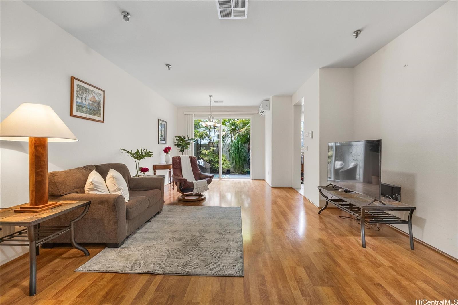 520 Lunalilo Home Road, Unit 313 Honolulu, HI 96825 - Photo 2 of 25 a living room with furniture and a wooden floor