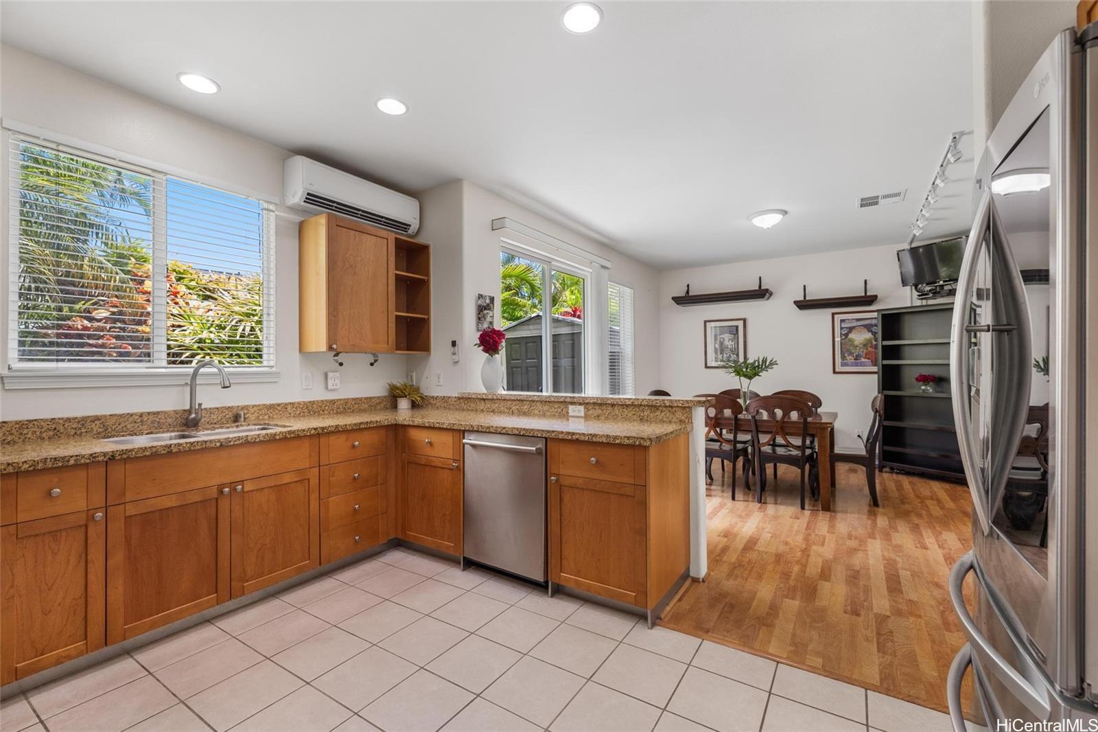 520 Lunalilo Home Road, Unit 313 Honolulu, HI 96825 - Photo 6 of 25 a kitchen with stainless steel appliances granite countertop a sink a stove a dining table and chairs