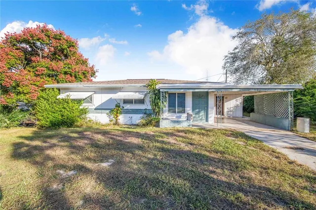 a view of a house with backyard and sitting area