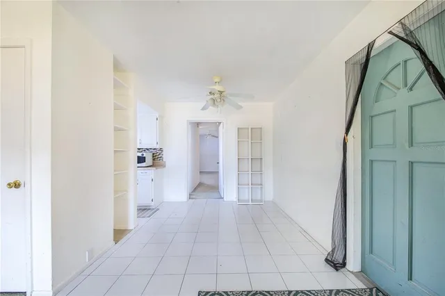 a view of a big room with windows and chandelier fan