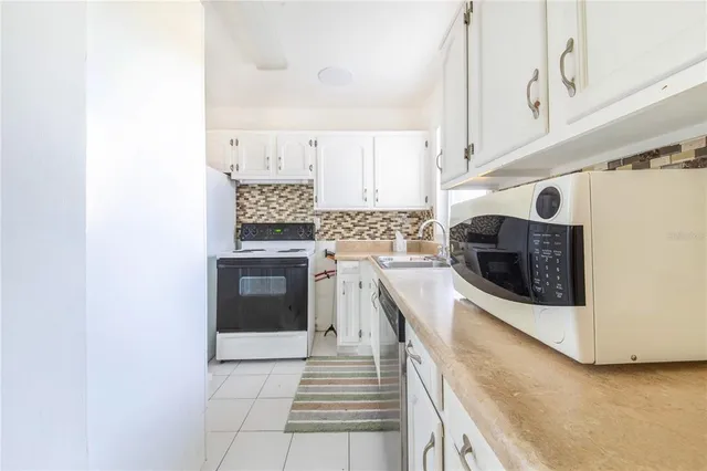 a kitchen with granite countertop a sink stove and refrigerator