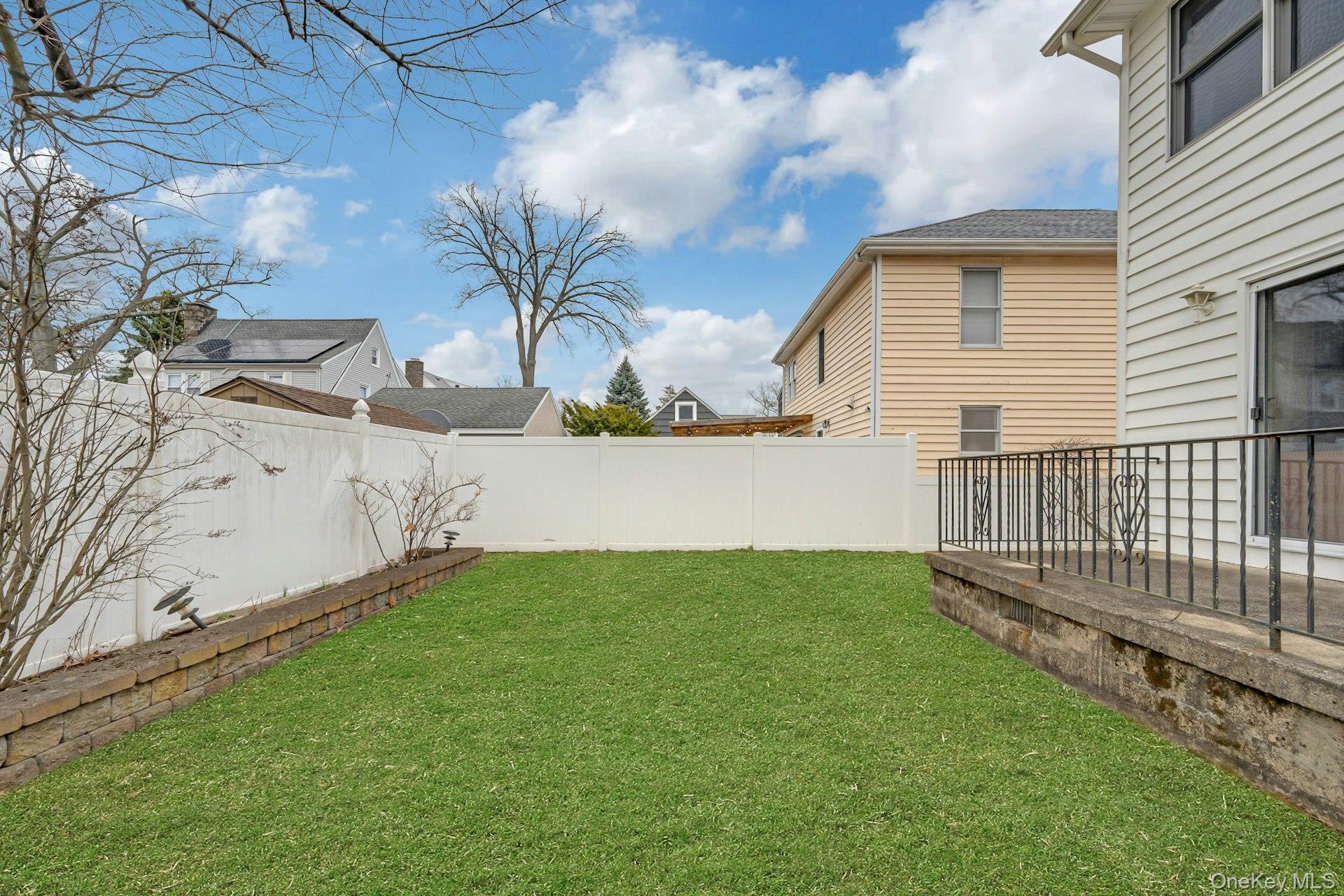 97 Bradley Road Scarsdale, NY 10583 - Photo 22 of 27 a view of a backyard with wooden fence