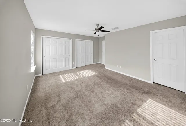 a view of empty room with ceiling fan