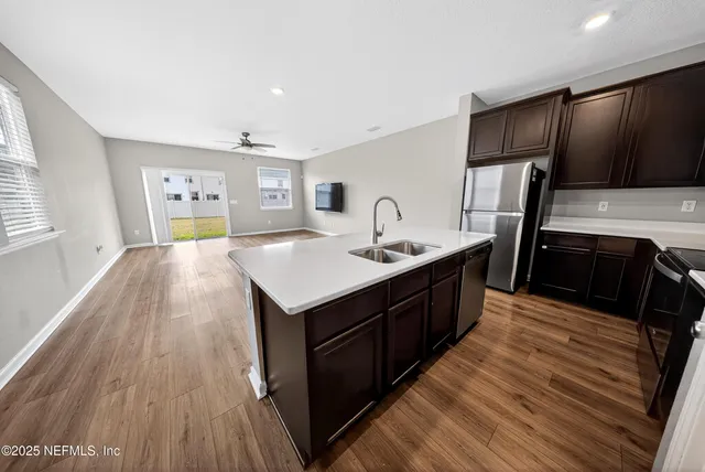 a kitchen with a sink and wooden floor