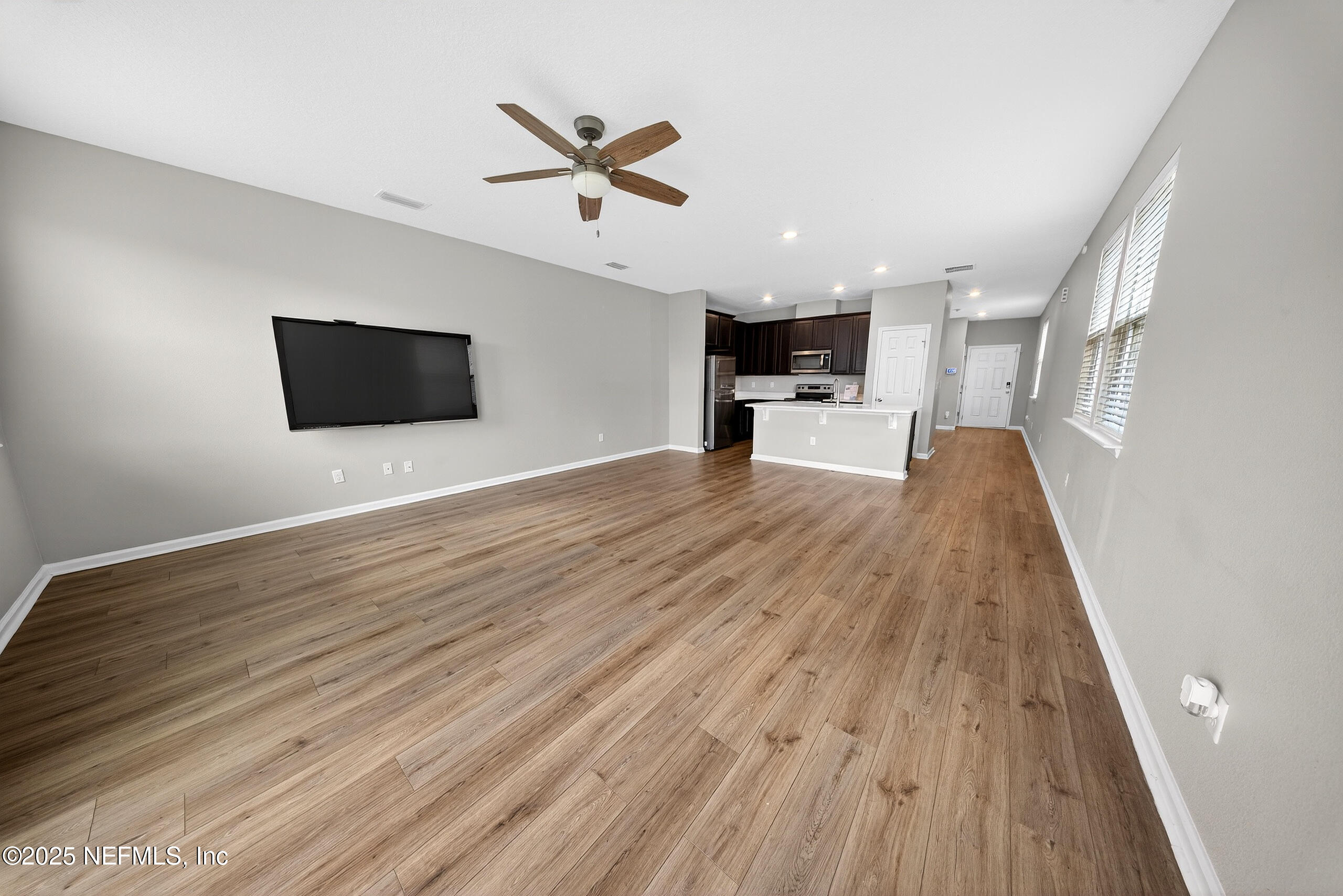9810 Fiddleback Lane Jacksonville, FL 32222 - Photo 4 of 20 a view of a livingroom with wooden floor and a ceiling fan