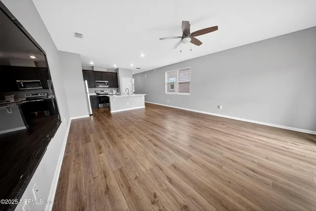 a view of a livingroom with hardwood floor and a ceiling fan