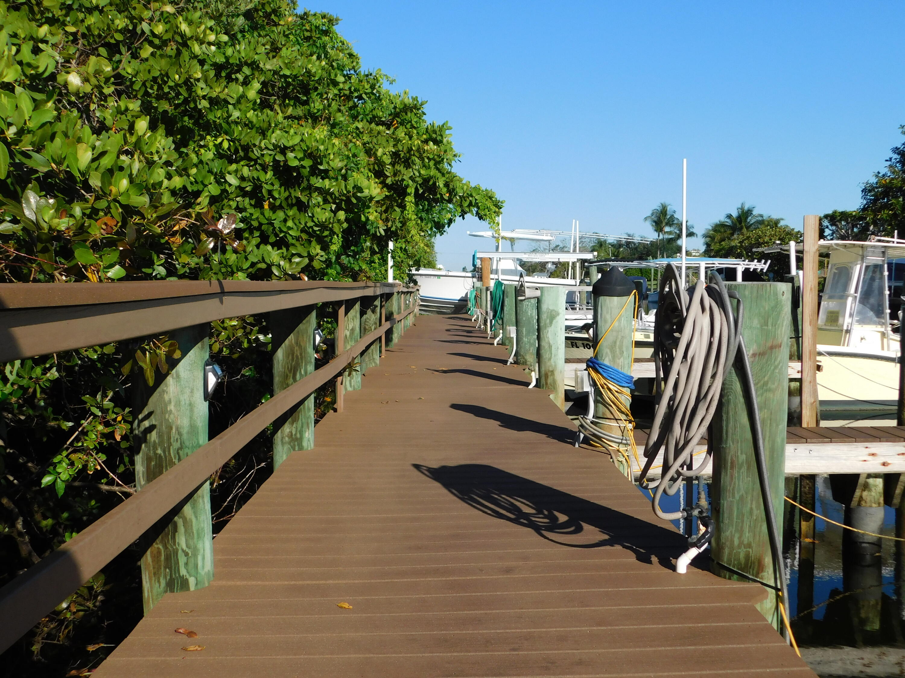 735 Hummingbird Way, Unit 202 North Palm Beach, FL 33408 - Photo 12 of 15 a view of a balcony with wooden floor and bench