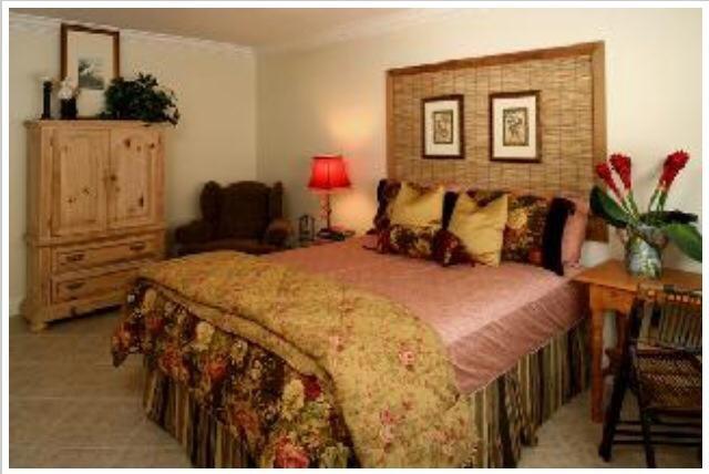 735 Hummingbird Way, Unit 202 North Palm Beach, FL 33408 - Photo 3 of 15 a bed room with a bed and a couch